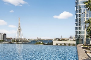 Une piscine avec vue sur un grand pont et des bâtiments modernes.