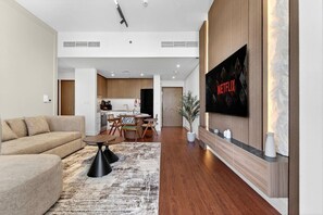 A modern living room with a sofa, coffee table, and a flat-screen TV mounted on the wall. - Spa / Gym / Sea View / High Floor / Marina Walk (Dubai)