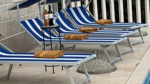 Ein Poolbereich mit Liegestühlen und Handtüchern.