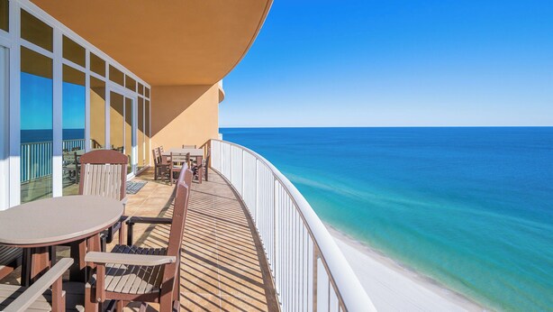 A balcony with a view of the ocean, a table, and chairs. - Phoenix Orange Beach 1802 Relax in Style (Orange Beach)