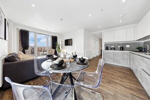A modern apartment with a dining area, kitchen, and living space. - Fantastic 2 bed Flat with amazing view in Barking (Barking)