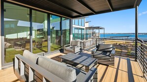 A modern outdoor deck with seating and a view of the sea. - Lake Luxury- Juniper Ridge-Pool Table and Beautiful Decor (Graford)
