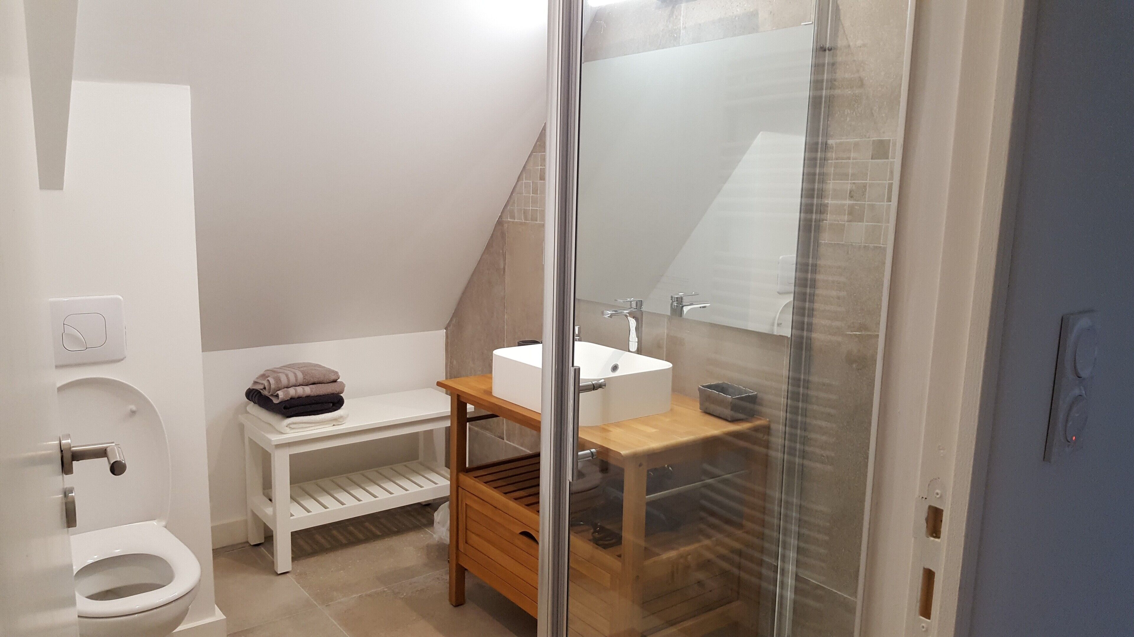 Een badkamer met toilet, wastafel en douchecabine.