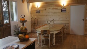 Ein Esszimmer aus Holz mit einem Tisch, Stühlen und einer Obstauslage.