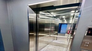An elevator with a metallic interior and a control panel on the right. - Family-Friendly Apartment • Walk to Parks & Shops • Safe and comfort for all. (Santiago)