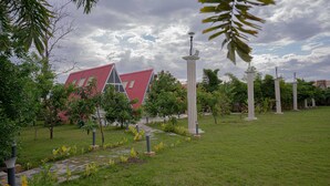 Un jardín bien cuidado con un sendero que lleva a un edificio de techo rojo.