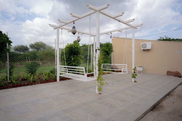Un espace extérieur abrité, doté d’une pergola, de sièges et d’une petite table.