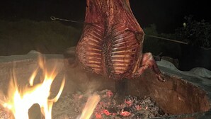 Un animal entier, rôti sur une broche au-dessus d’un feu de bois.