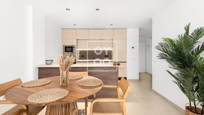 A modern dining area with a round wooden table, woven placemats, and wicker chairs. - Amalia Garden Groundfloor Retreat, a footstep from beach and sea, By OYOOSTAYS (Torrevieja)
