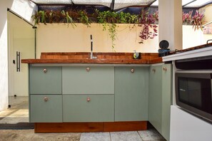Eine Küche mit einem grünen Schrank, einer Holz Arbeitsplatte und einem eingebauten Backofen.