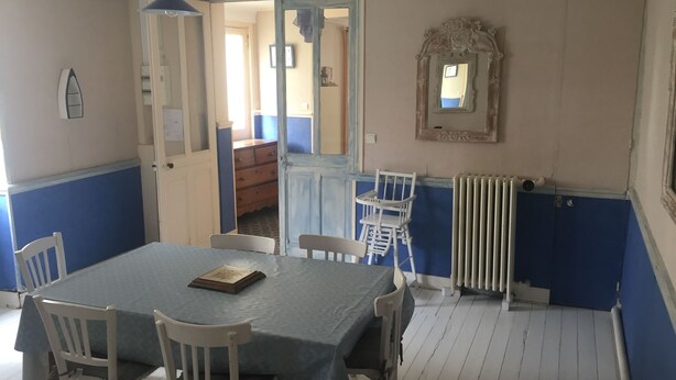 En matplats med ett bord dukat för fyra personer, en spegel och ett element.