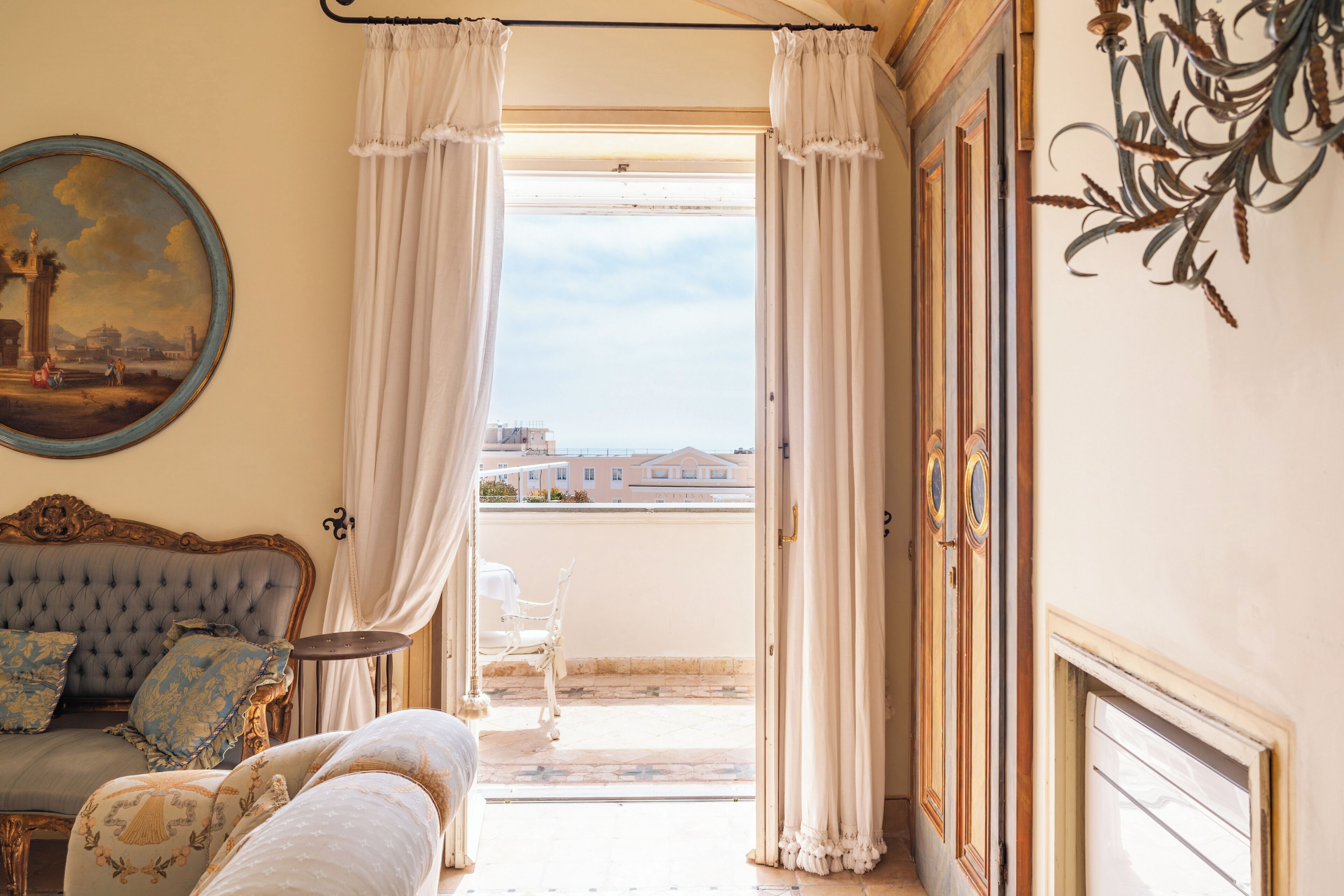 Habitación con vistas a edificios, un sofá, una silla y una mesa.