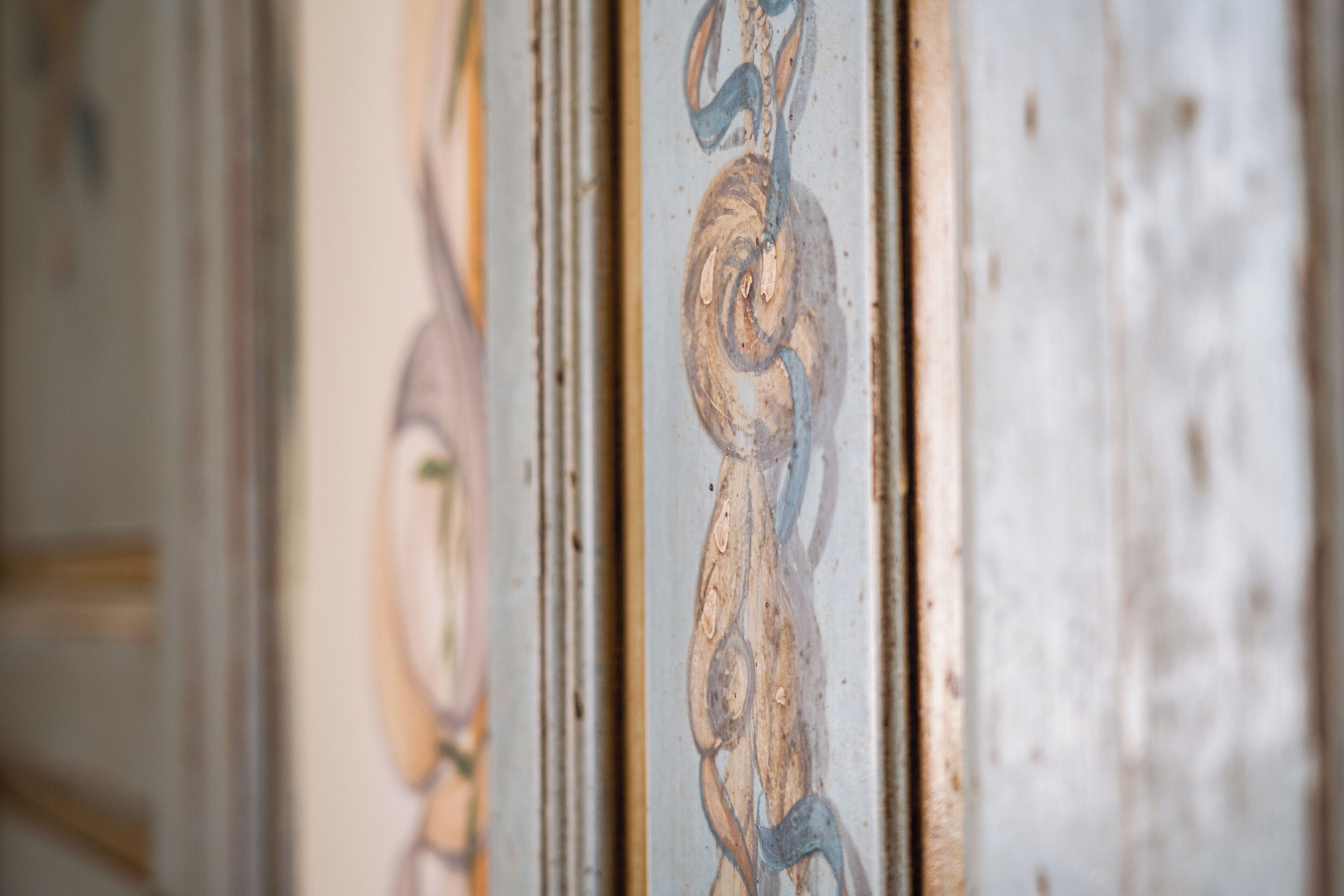 A close-up of a wall with decorative moldings and a partial view of a door frame.