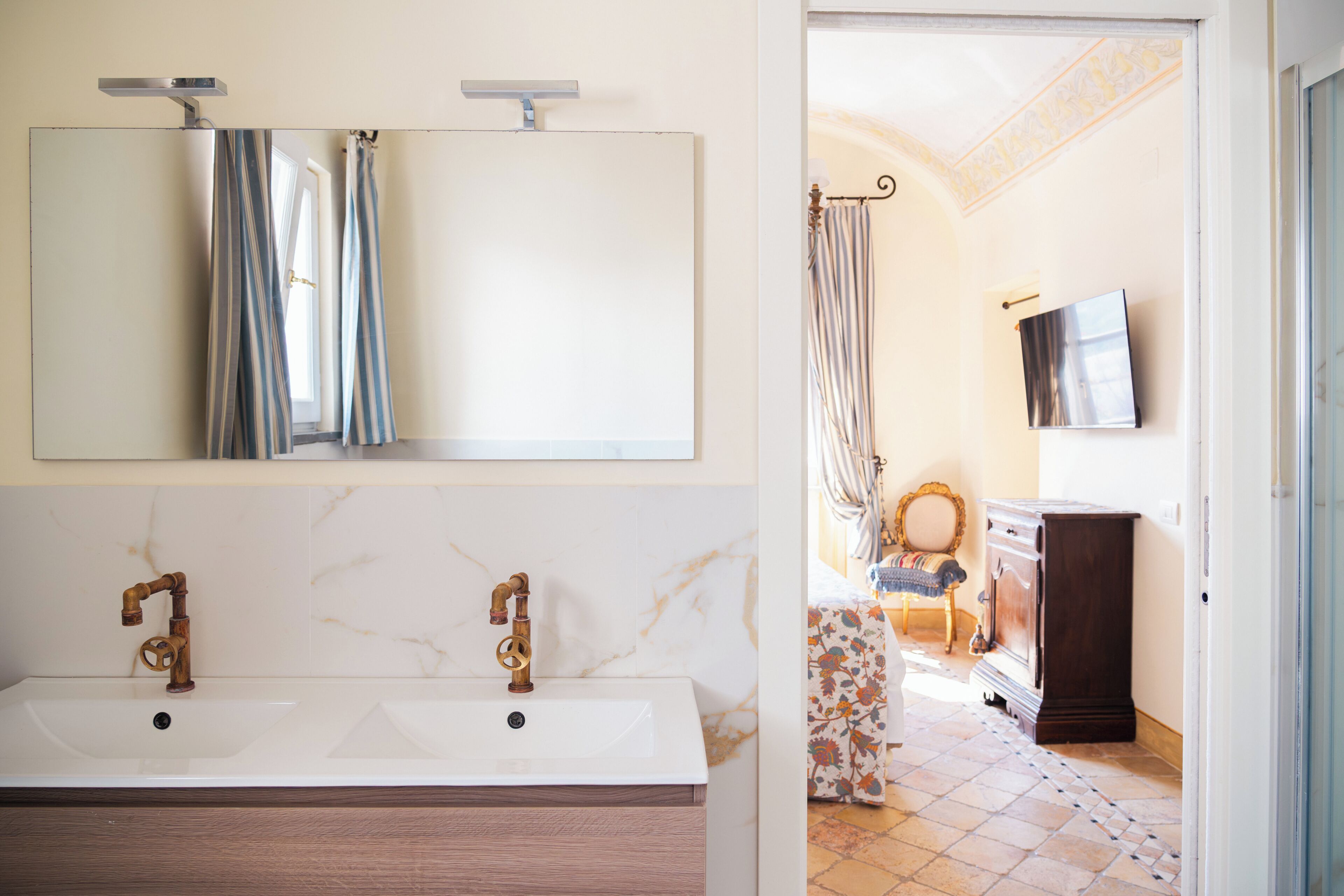 A bathroom with a double sink, a mirror, and a shower curtain.