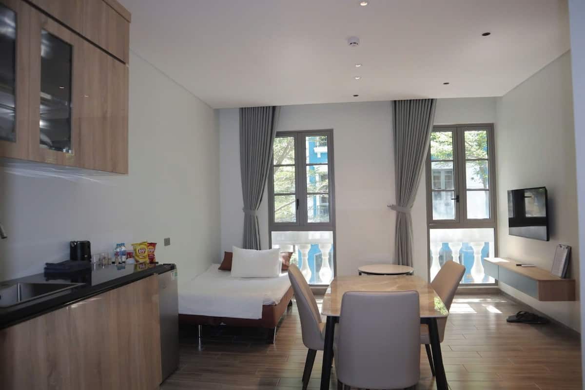 Una habitación moderna con una cama, una mesa de comedor y un televisor.