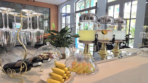 Un buffet garni de divers plats, une bouteille de vin et une plante en pot.