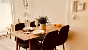 Un comedor con una mesa de madera, sillas negras y una planta en maceta.