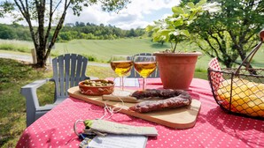 Un montaje para picnic con una mesa, sillas, una planta, una cesta y alimentos.