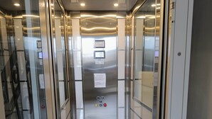 Un ascenseur doté d’un écran numérique, de boutons d’urgence et d’un indicateur d’étage.