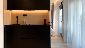 Una cocina moderna con armarios oscuros, un lavamanos de acero inoxidable y una campana extractora empotrada.