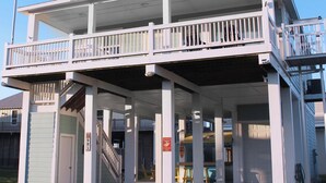 A two-story building with a balcony, a flagpole with an American flag, and a sign indicating 'Marines Only' parking. - Your Coastal Getaway:3BR/2BA Beach Retreat (Bolivar Peninsula)