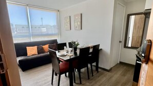 Un salon moderne avec un coin repas, comprenant un canapé, une table à manger et des chaises.