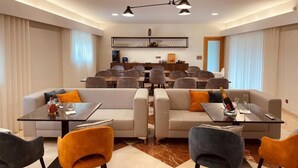 A modern hotel room with a dining area, two sofas, a coffee table, and a bar area. - Casa de Lamaçais (Paredes)