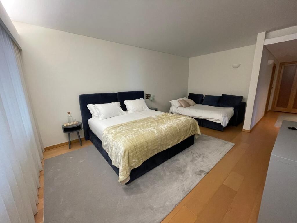 Ein Schlafzimmer mit zwei Betten, einem kleinen Nachttisch und einem Beistelltisch.