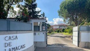 A gated entrance with a sign reading 'CASA DE LAMACAIS' and a building in the background. - Casa de Lamaçais (Paredes)