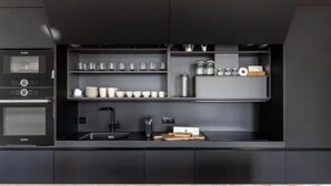 Una cocina moderna con electrodomésticos integrados, incluyendo una estufa y horno, y una encimera con estantes de almacenamiento.