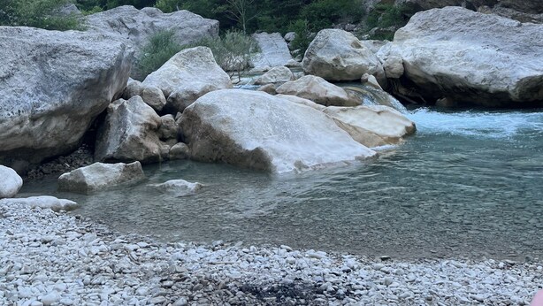 A natural landscape with a river, large rocks, and a mountainous backdrop. - Gîte Métairie la Faurie in the heart of Drôme (Aurel)