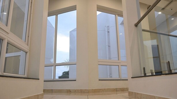 Un intérieur spacieux avec de grandes fenêtres, un plancher poli et un design de plafond moderne.