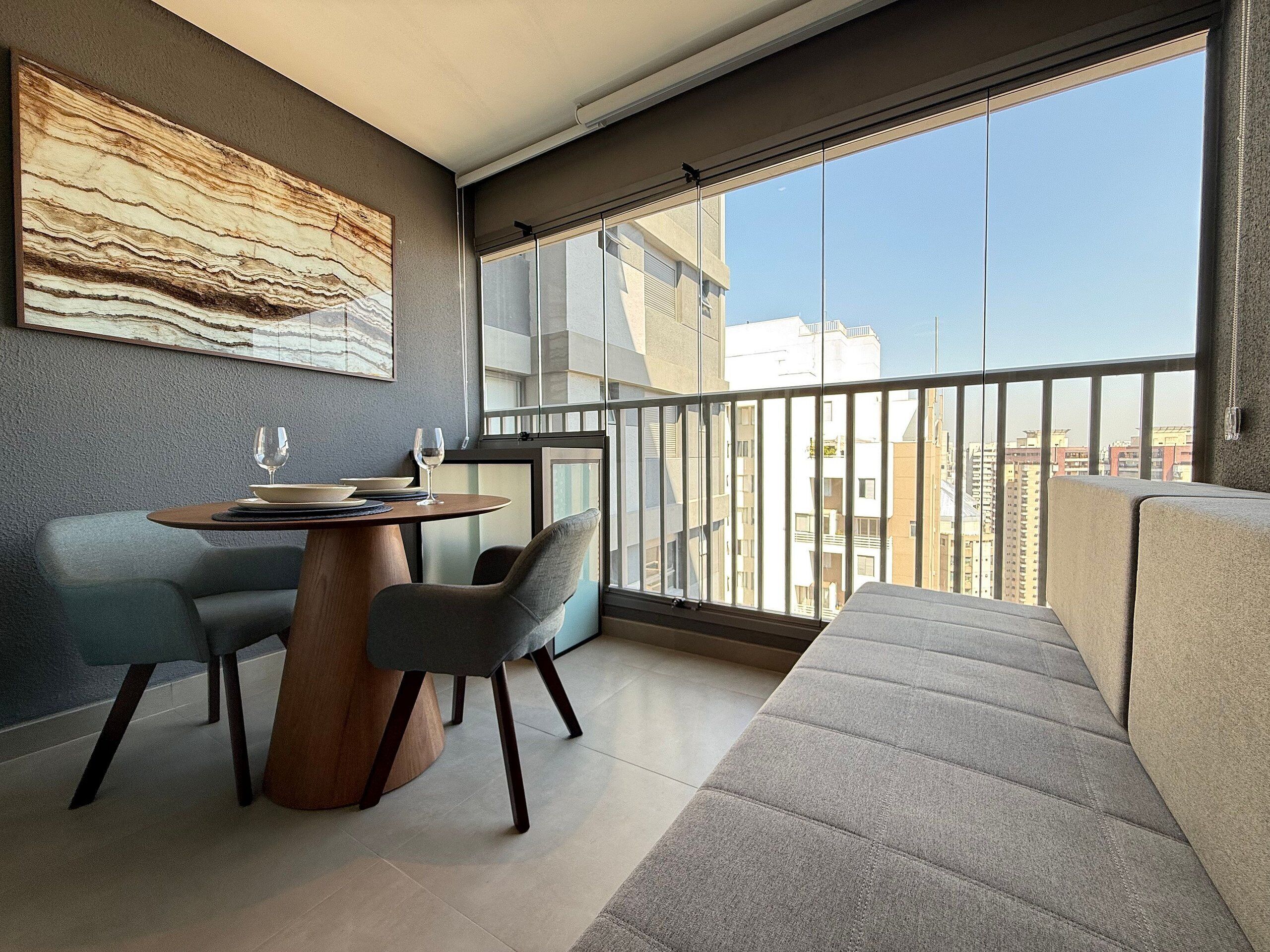 A modern living room with a dining area, large windows, and a city view.