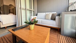 A modern living room with a sofa, a coffee table with a plant, and a large window with curtains. - Livinn - On Jurupis (São Paulo)