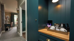 Ett hotellrum med turkosa väggar, en träinredd receptionsdisk och en spegel.