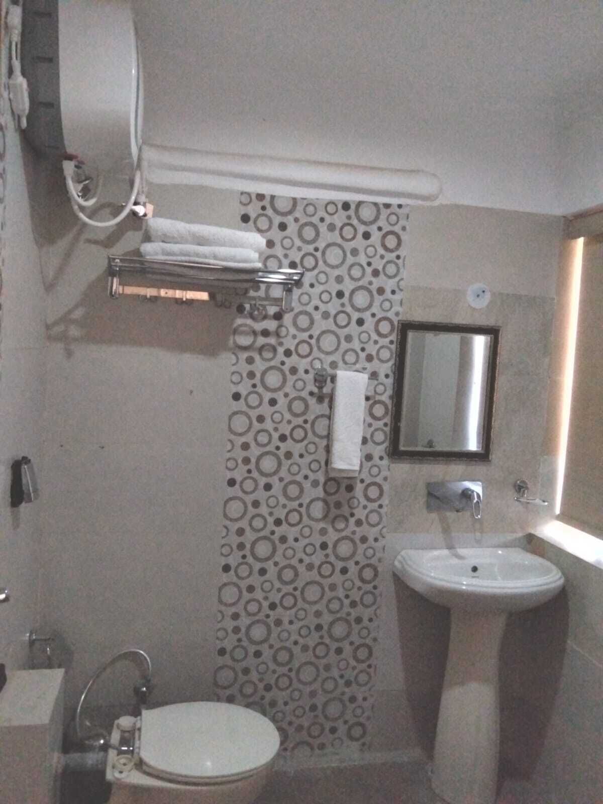 A bathroom with a toilet, sink, and towel rack.