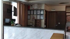A modern kitchen with marble countertops, a built-in microwave, and a ceiling fan. - HOTEL CASA DOON (Dehradun)