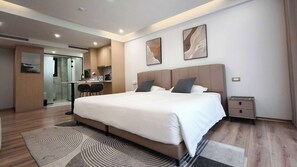 A modern hotel room with a large bed, a desk with a chair, and two wall-mounted paintings. - Sleek Apartment in the Heart of Piraeus (Piraeus)
