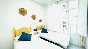 Une chambre d’hôtel avec deux lits, une fenêtre donnant sur un paysage agréable et une porte.