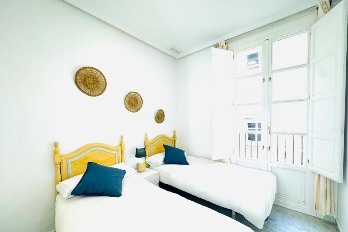 Une chambre d’hôtel avec deux lits, une fenêtre donnant sur un paysage agréable et une porte.