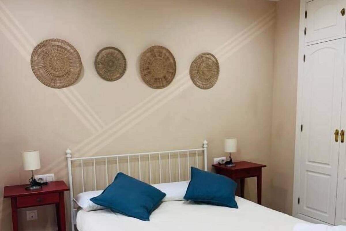 Une chambre à coucher comprenant un lit, deux tables de chevet, une armoire et quatre éléments de décoration murale.
