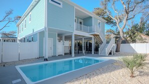Une maison à deux étages dotée d’une piscine, d’un patio couvert et d’un escalier menant à l’étage supérieur.