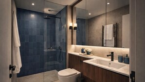 Ein modernes Badezimmer mit einer Duschkabine, einer weißen Toilette und einem Waschtisch mit Waschbecken und Spiegel.