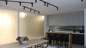 Una cocina moderna con una mesa de comedor de madera, taburetes de bar y una isla de cocina.