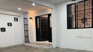A room with a tiled floor, a black door, and a window with a brick pattern.