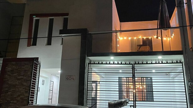 A modern building with a garage door, a balcony with string lights, and a visible number 404 sign.