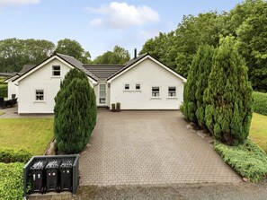 A two-story white house with a paved driveway, surrounded by well-maintained greenery and a clear sky. - "Elizabeth" - 175m from the sea by Interhome (Aabenraa)