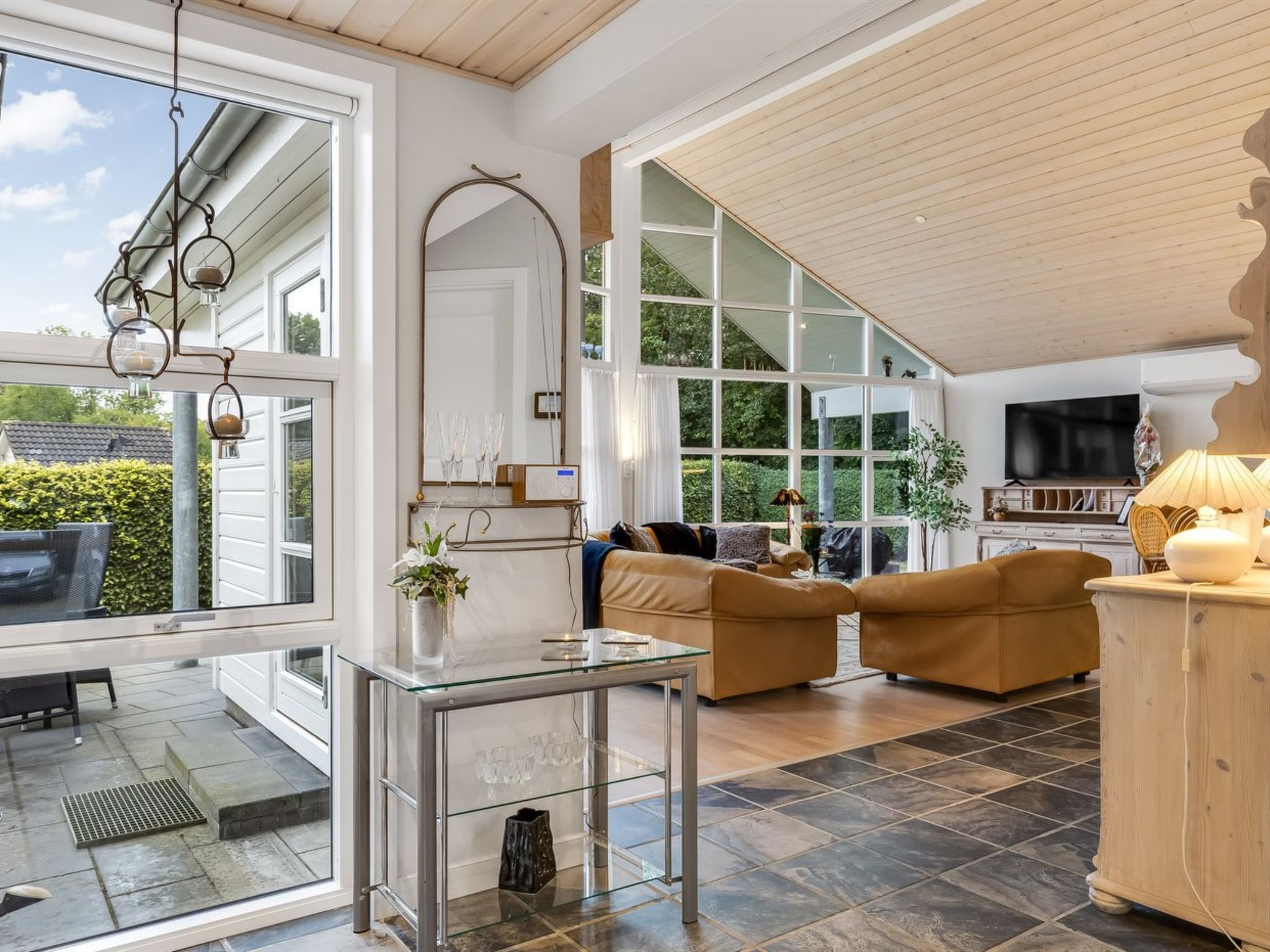 A spacious living area with a glass coffee table, a sofa set, and a television.