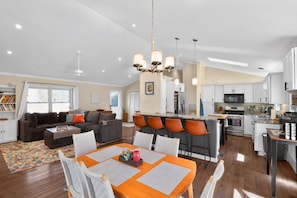A modern open-plan living space with a dining area, kitchen, and bar. - Luxury Fireplace Home, Deck & Views Near Biltmore (Asheville)