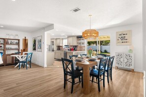 A modern kitchen with a dining area, wooden flooring, and a chandelier. - 1258 Seminole Drive (Indian Harbour Beach)